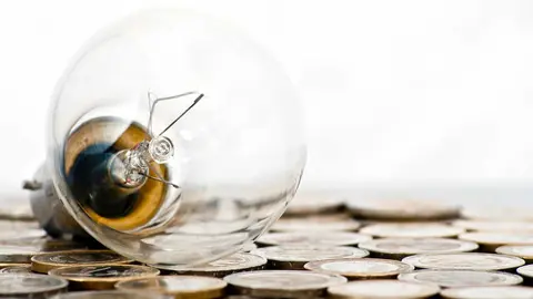 filament bulb lying on euro coins