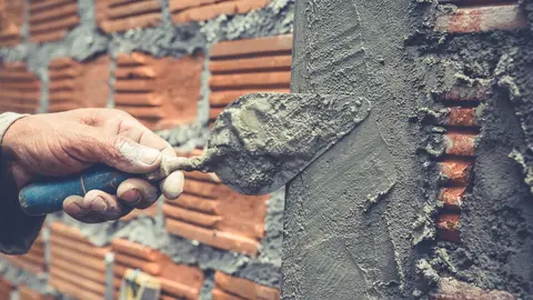 Bricklaying. Construction worker building a brick wall.