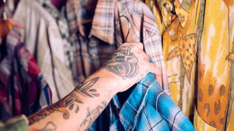close-up-man-s-hand-holding-blue-shirt-rail-clothing-shop (1)